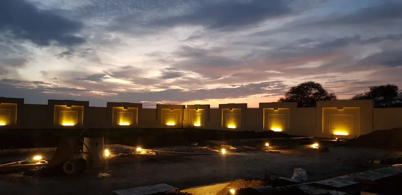 The residences and lit boundary niches under a violet-rose sunset